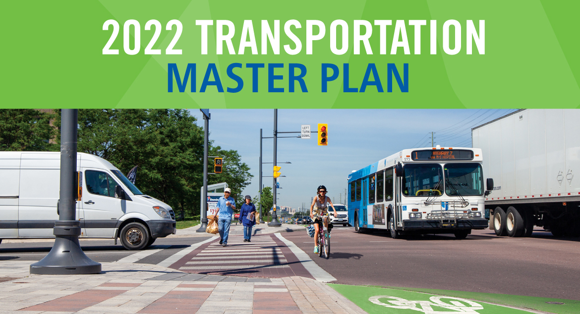 Words that say 2022 Transportation Master Plan and an intersection showing vehicles and people crossing the street Words that say 2022 Transportation Master Plan and an intersection showing vehicles and people crossing the street